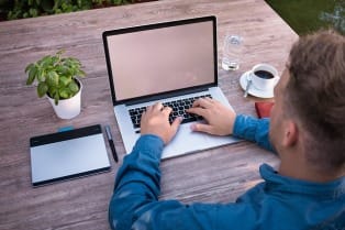 man typing on laptop